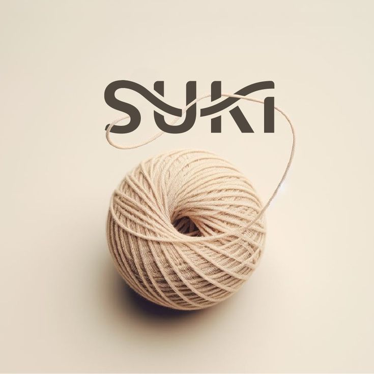 a ball of yarn sitting on top of a white surface next to the word suki