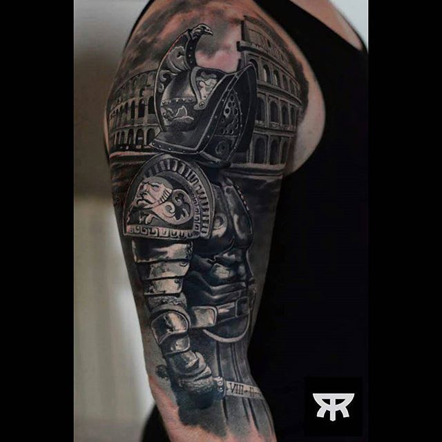 a man's arm with a black and grey tattoo design on it, including a helmet