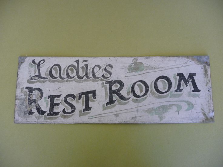 a sign that reads ladies'rest room on the side of a yellow painted wall