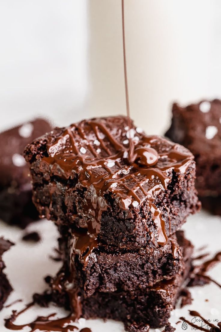 two chocolate brownies are stacked on top of each other and one has a bite taken out of it