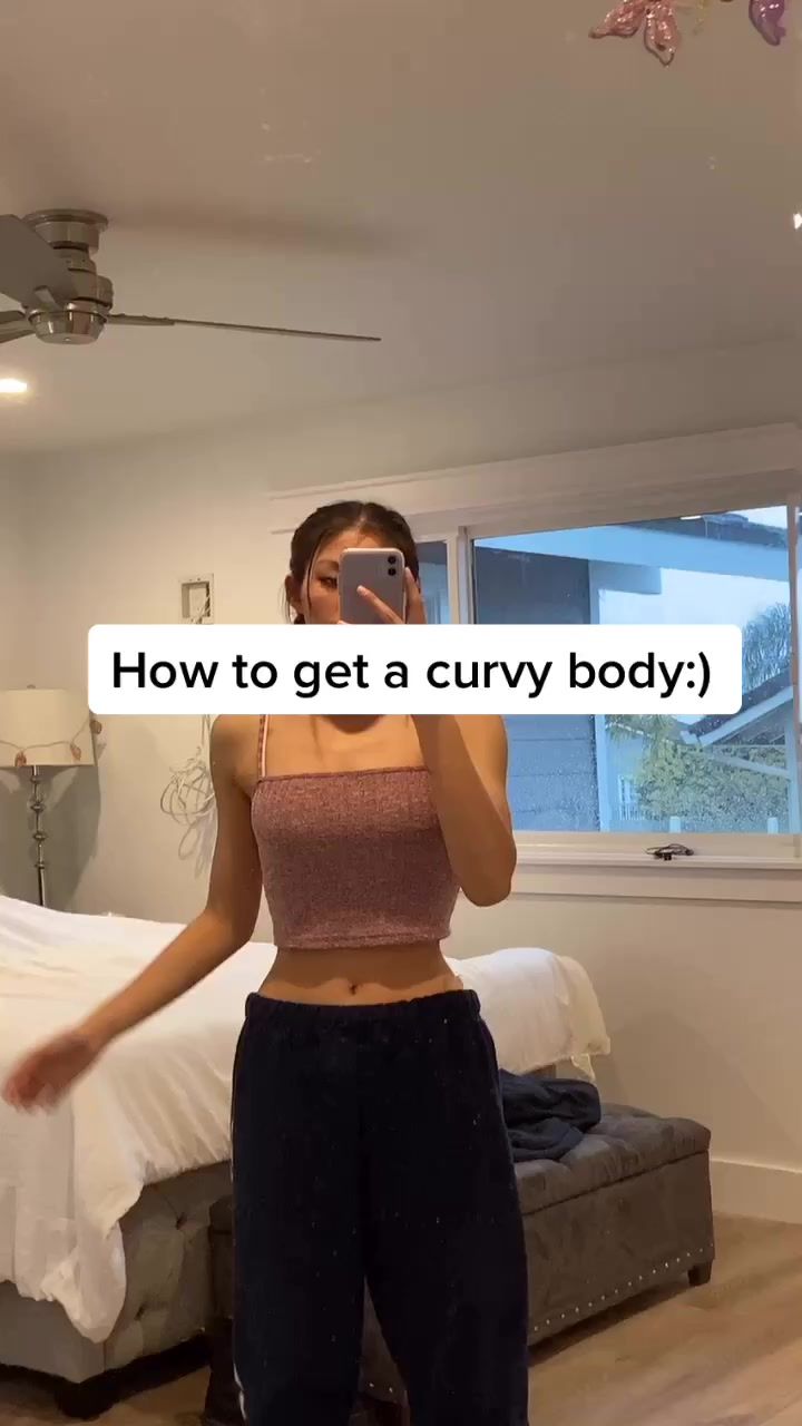 a woman taking a selfie in front of a bed with the caption how to get a curvy body