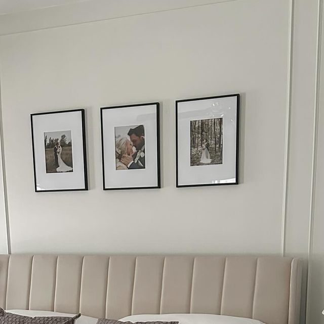 three framed pictures hang on the wall above a bed in a room with white walls