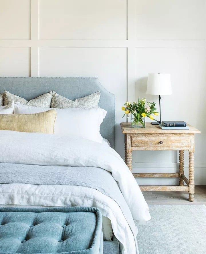 a bedroom with white walls and blue bedding