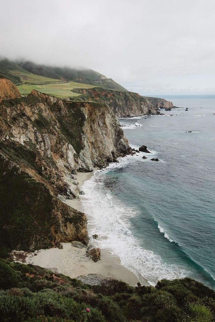 an ocean view with waves crashing on the shore