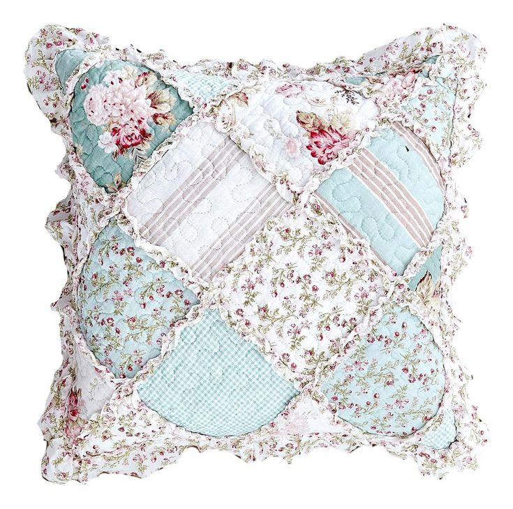 a blue and white pillow with patchwork on the front, along with pink flowers