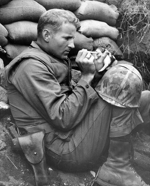 an old photo of a man sitting on the ground with his head in his hands