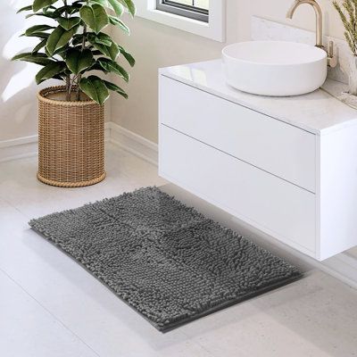 a bath room with a sink and a plant next to the toilet bowl on the counter