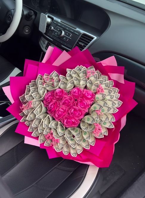 a car dashboard decorated with pink roses and money in the shape of a love heart