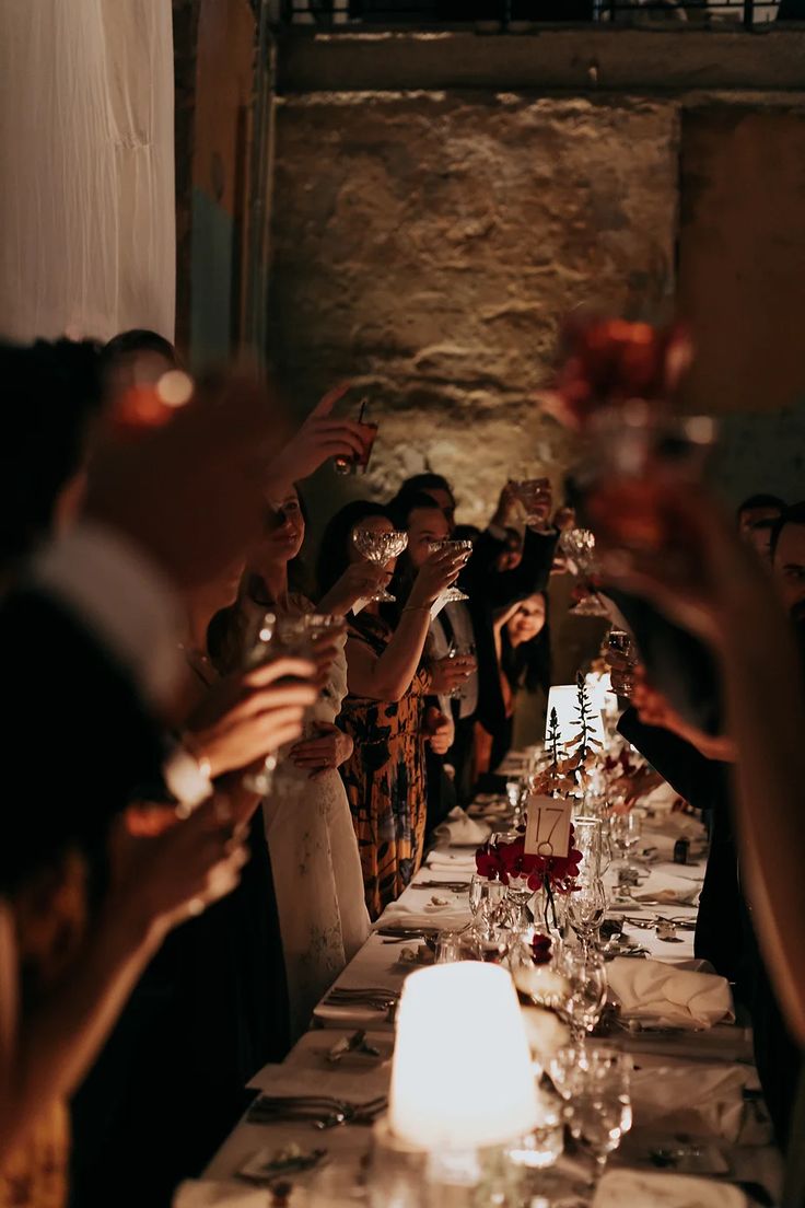 a group of people standing around a long table with wine glasses on top of it