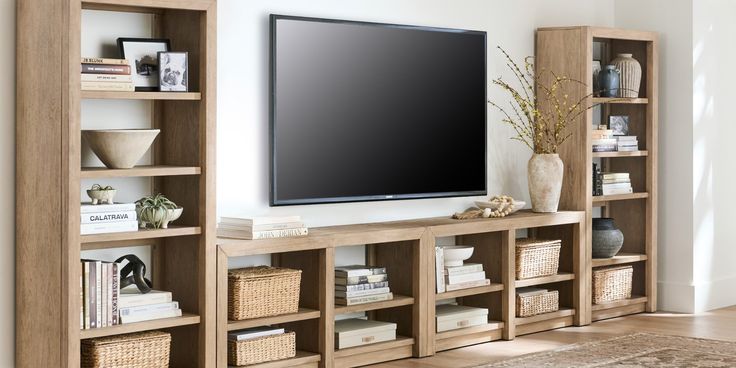 a large flat screen tv mounted to the side of a wooden bookcase in a living room