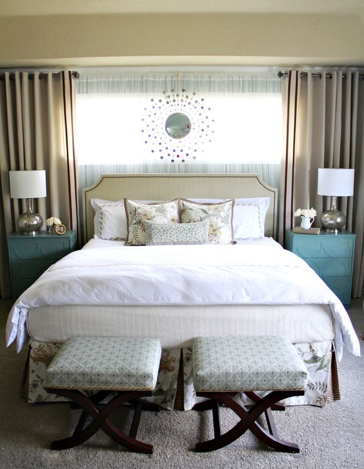 a bedroom with a large bed and two stools in front of the headboard