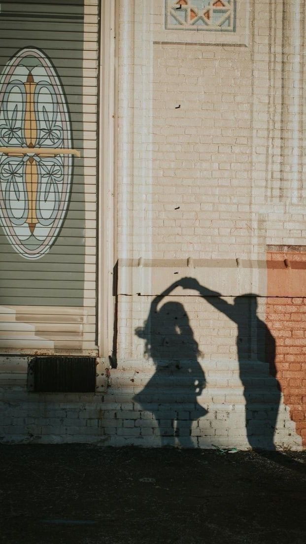 the shadow of a person standing in front of a building