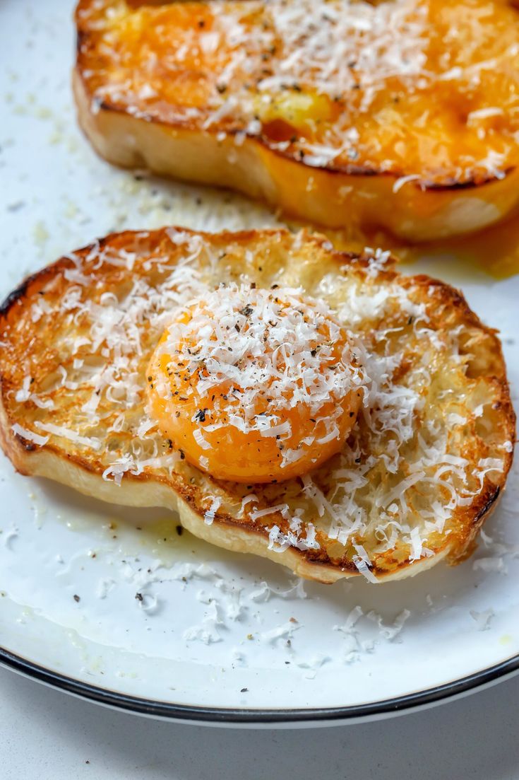 two pieces of bread on a plate with parmesan cheese and pineapple toppings