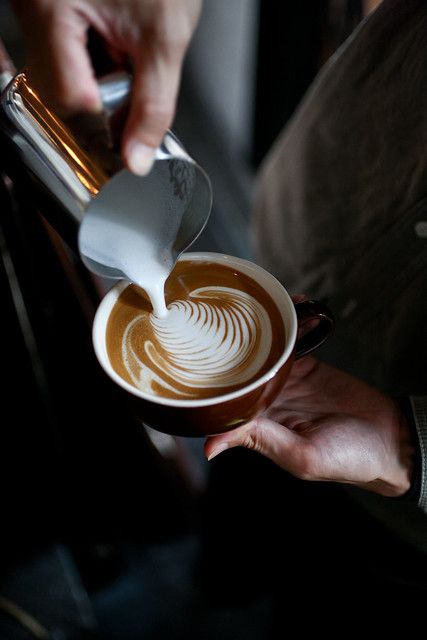 a person pours coffee into a cup