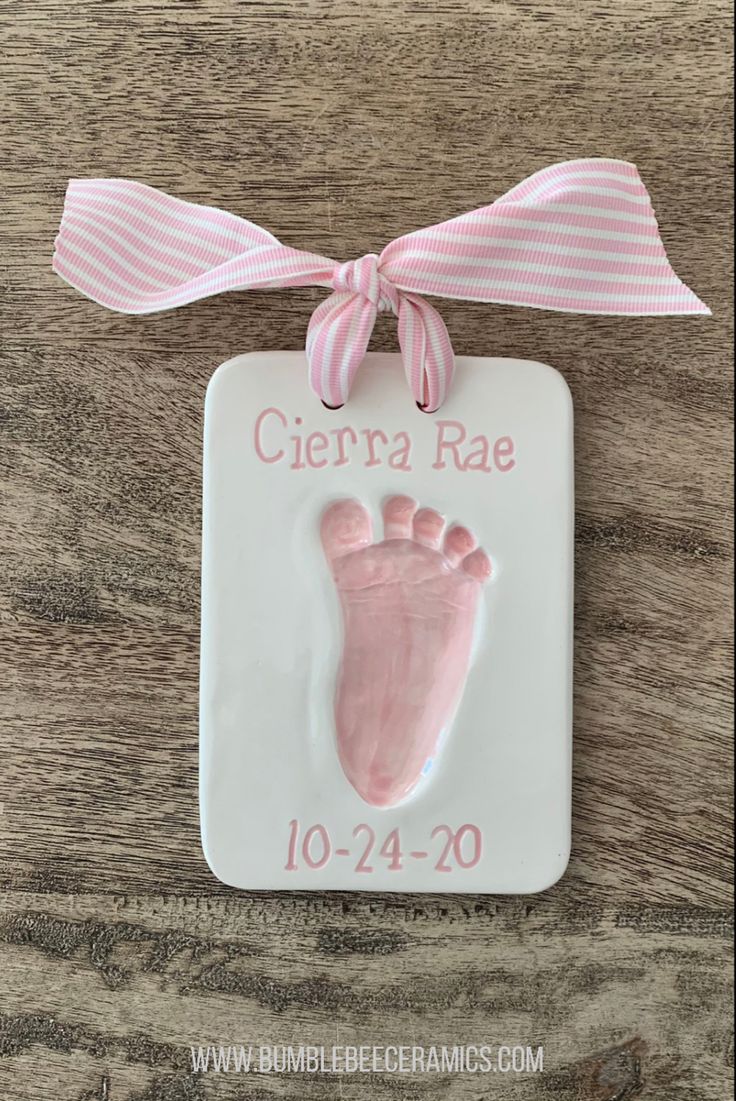 a ceramic ornament with a baby's hand and foot imprint on it