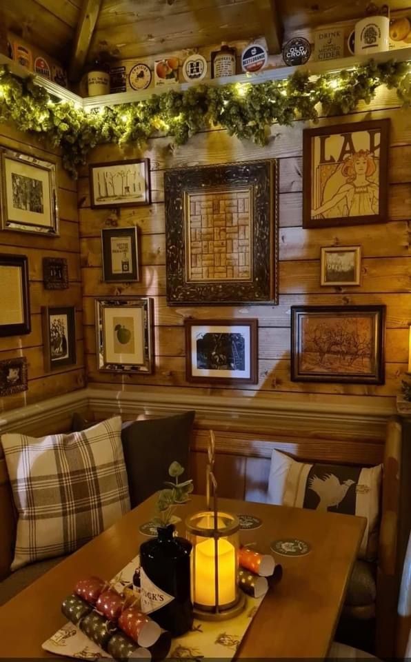 a dining room with wooden walls and pictures hanging on the wall, along with candles