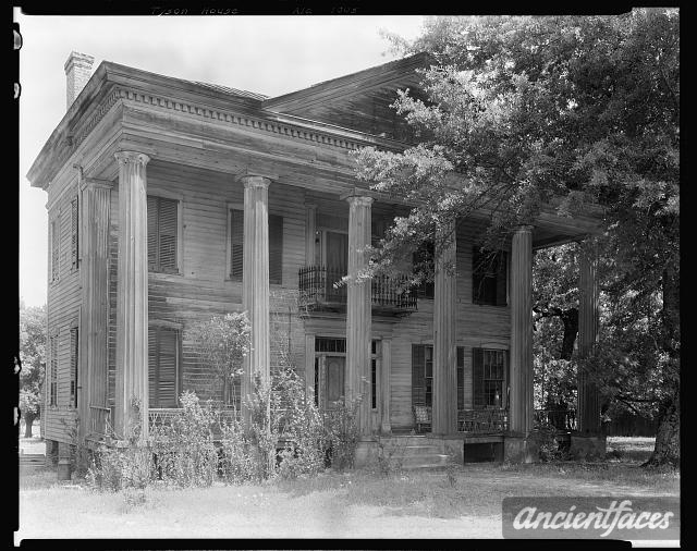 an old wooden house with columns and pillars