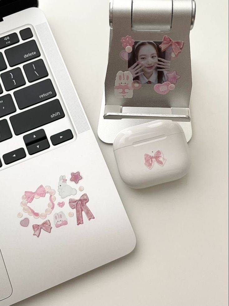 an open laptop computer sitting on top of a white desk next to a mouse and photo