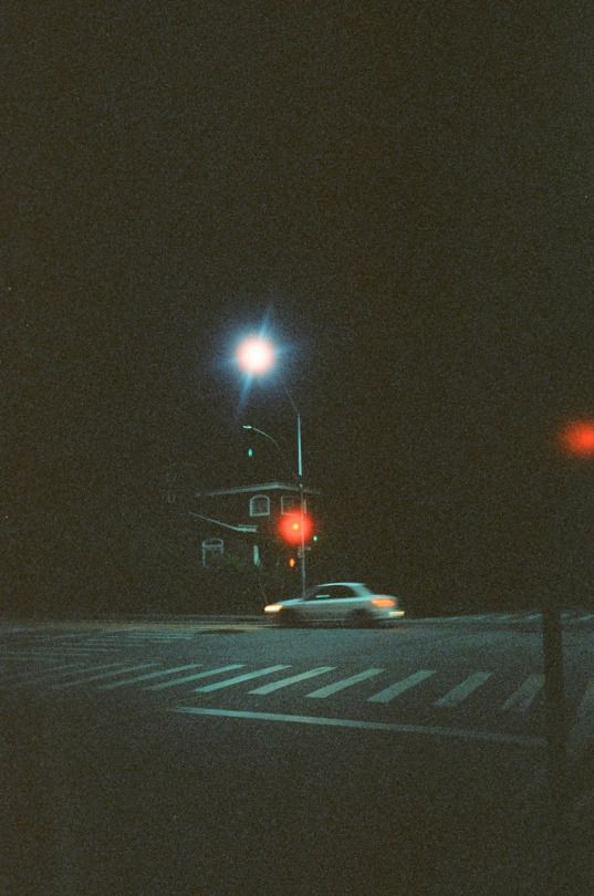 a car is driving down the street at night