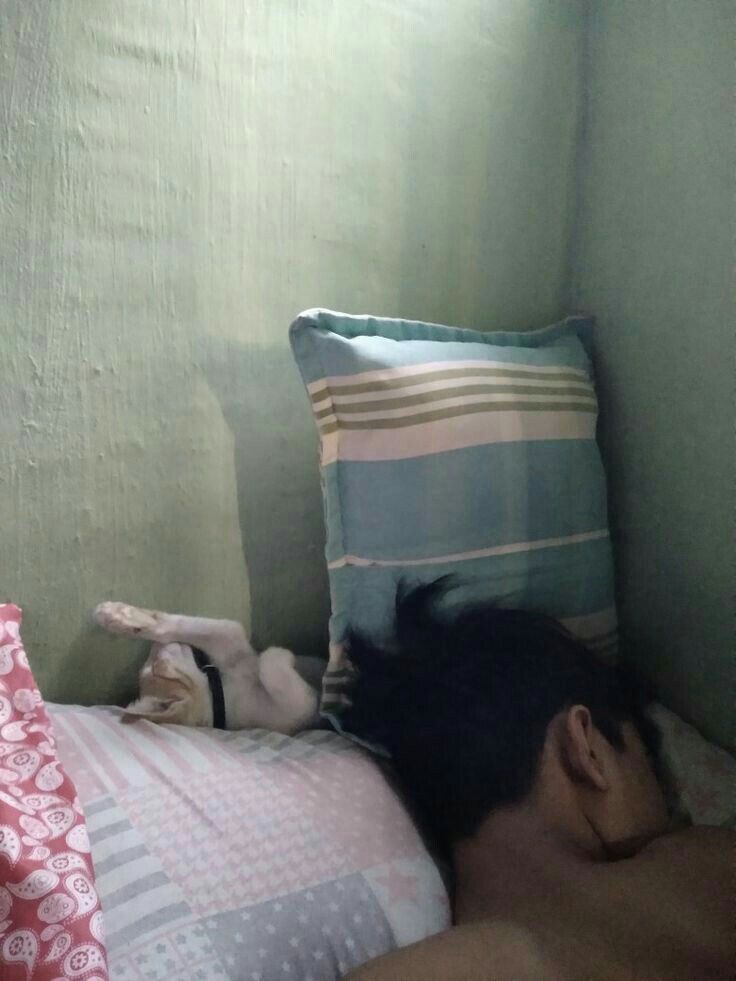 a man laying in bed with his head on the pillow