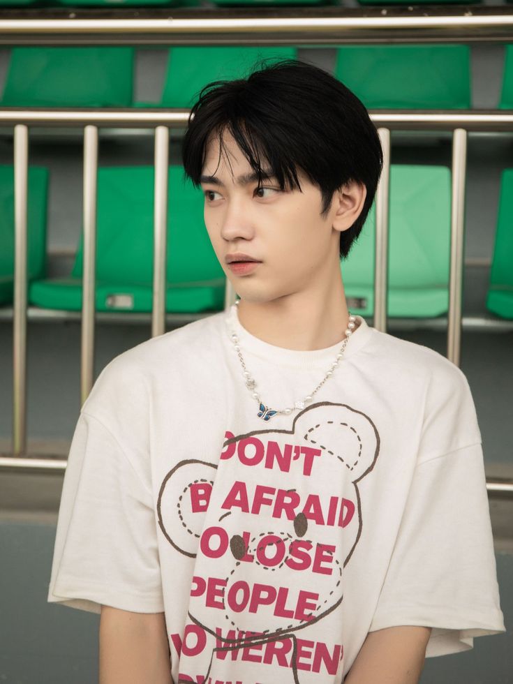 a young man with black hair wearing a t - shirt that says don't be afraid to close people to where you are going