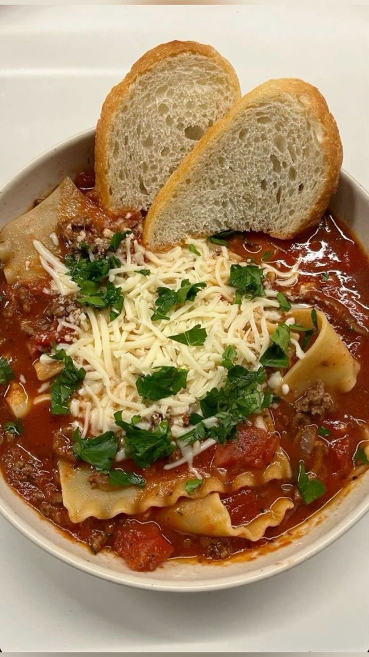 a white bowl filled with pasta and bread