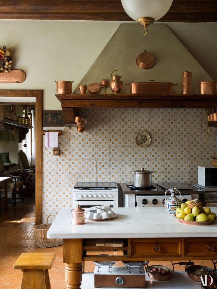 a kitchen with an oven, stove and fruit bowl on the counter in front of it