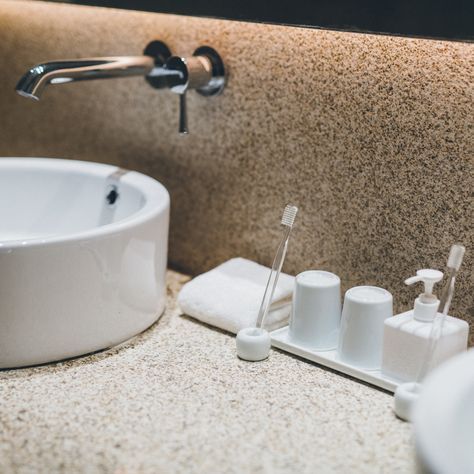 a bathroom sink with soap and toothbrushes on the counter top next to it