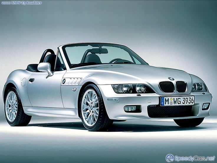 a silver bmw z3 roadster parked in front of a gray background