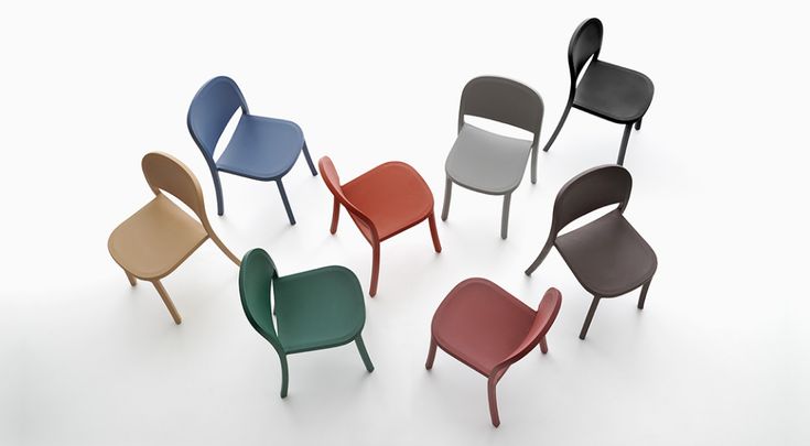 six different colored chairs sitting next to each other on a white surface with one chair facing the camera