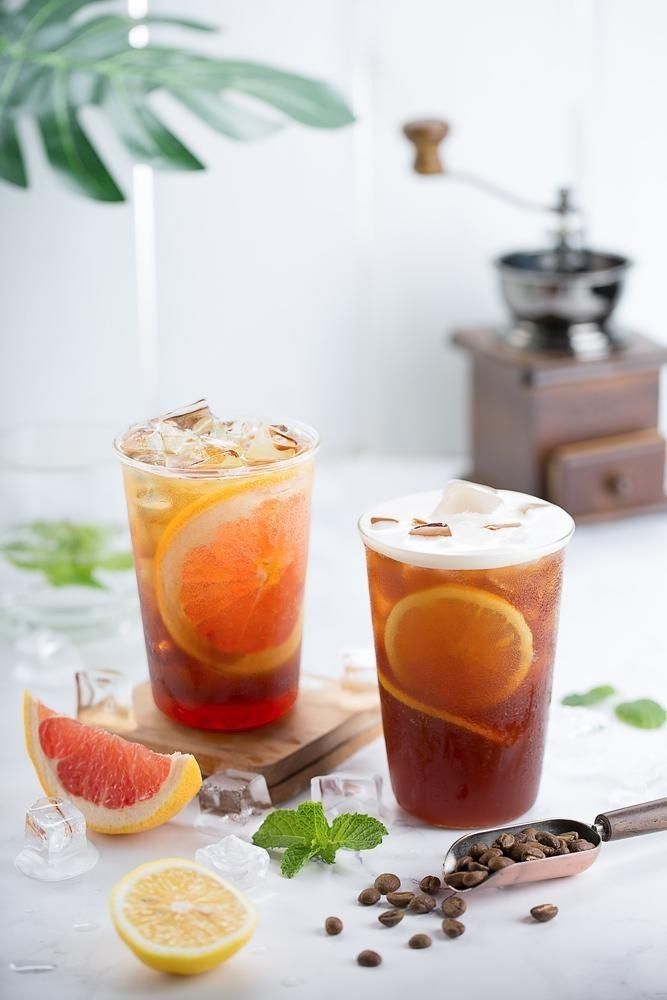 two glasses filled with iced tea and orange slices