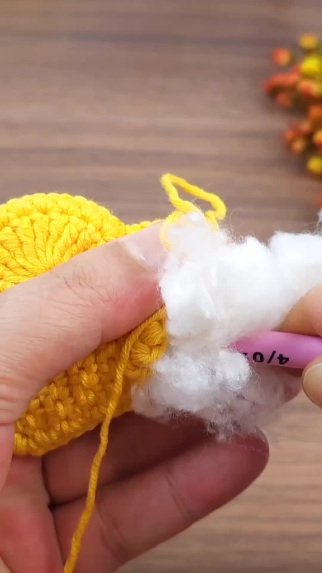 This may contain: someone is crocheting the end of a yellow piece of yarn with white wool