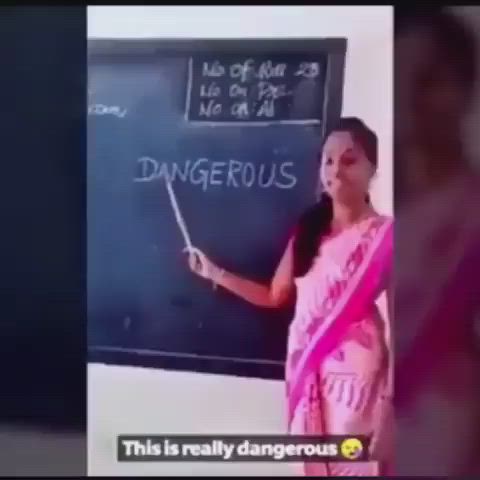 This may contain: a woman standing in front of a blackboard with writing on it and pointing to the chalk board