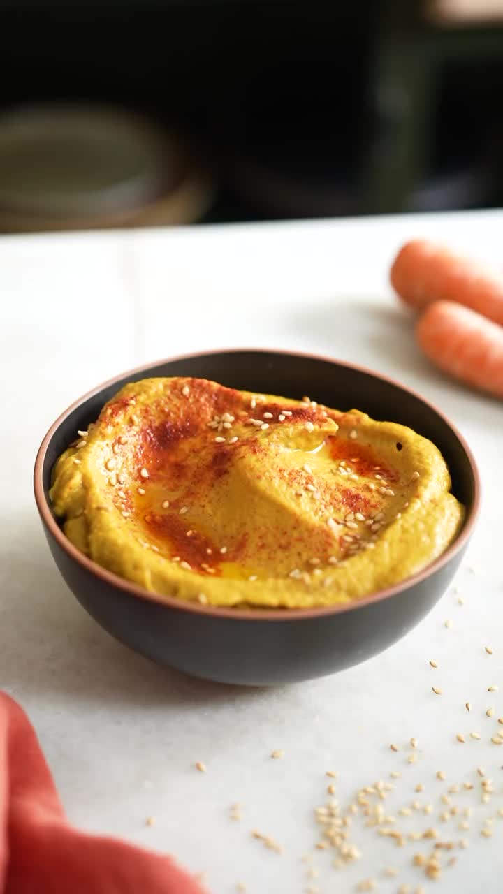 This may contain: an omelet in a black bowl on a table with carrots