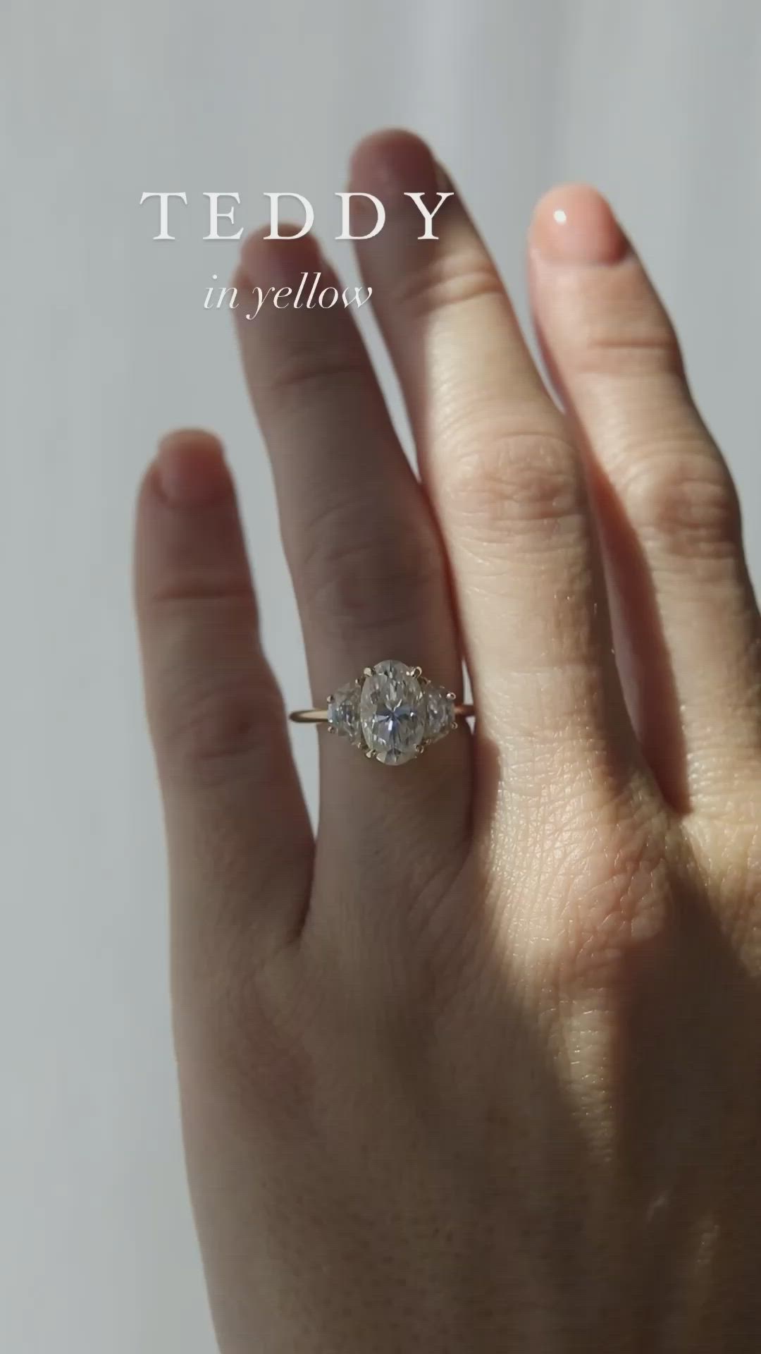 This may contain: a woman's hand with a diamond ring on it and the words teddy in yellow