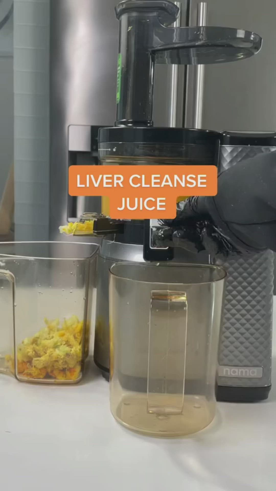 This may contain: there is a juicer with orange liquid in it and other containers around it on the table