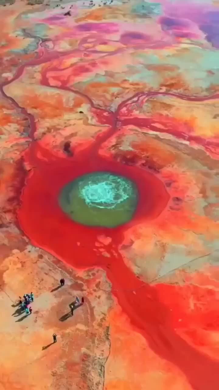 This may contain: an aerial view of the earth's colorfully colored water and land, with people walking around it