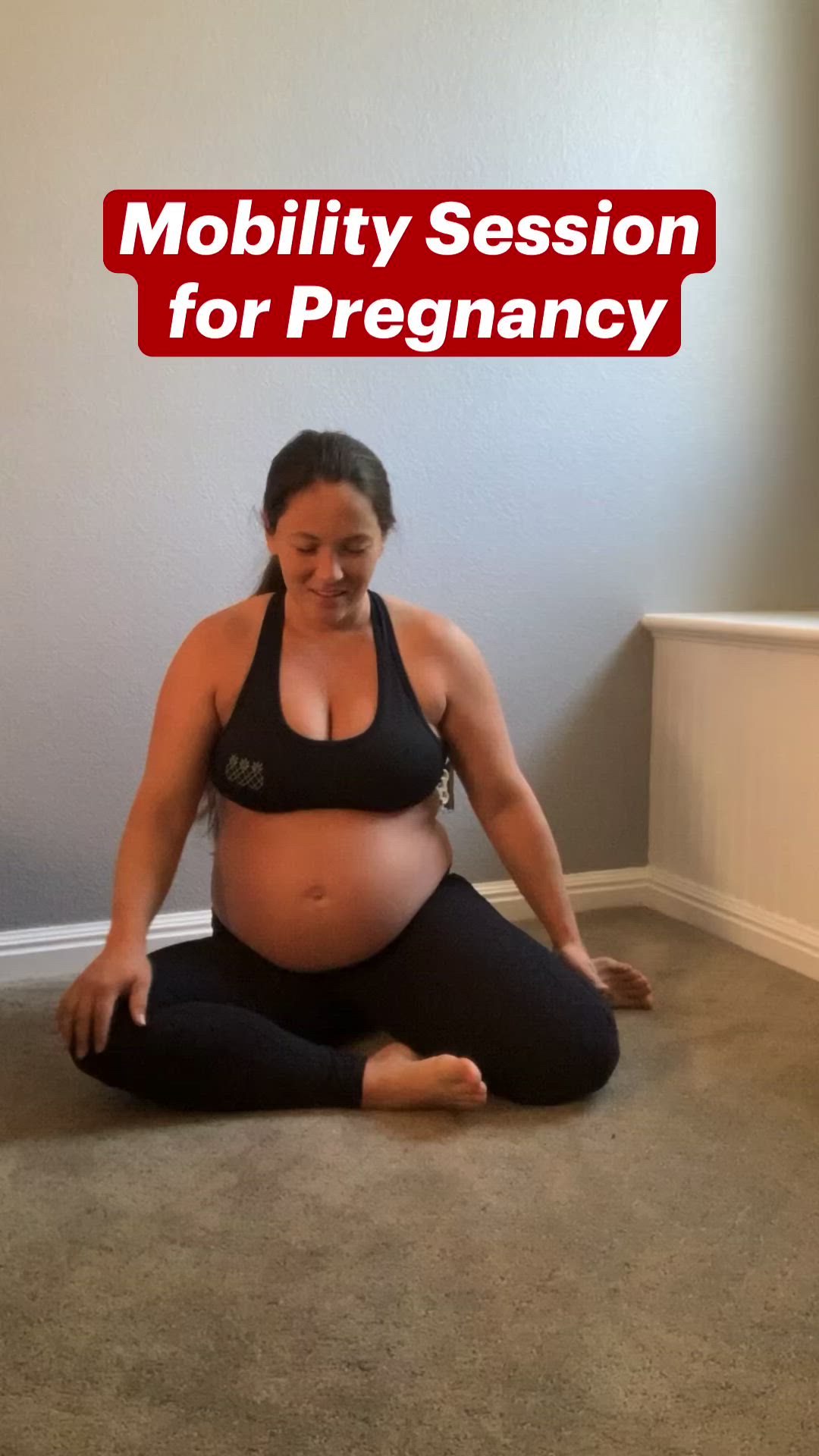 This may contain: a pregnant woman sitting on the floor doing yoga