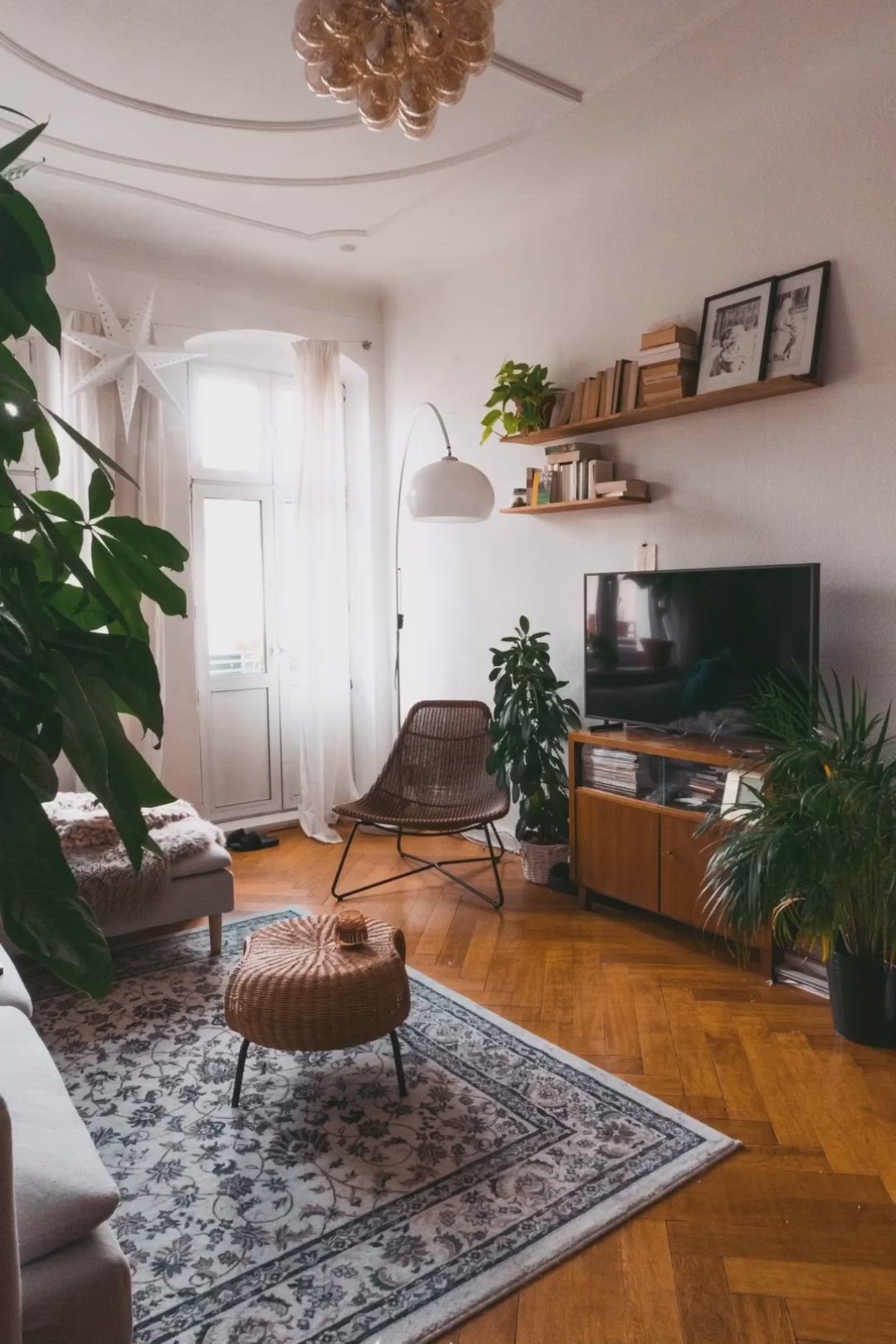 This may contain: a living room filled with furniture and a flat screen tv on top of a hard wood floor