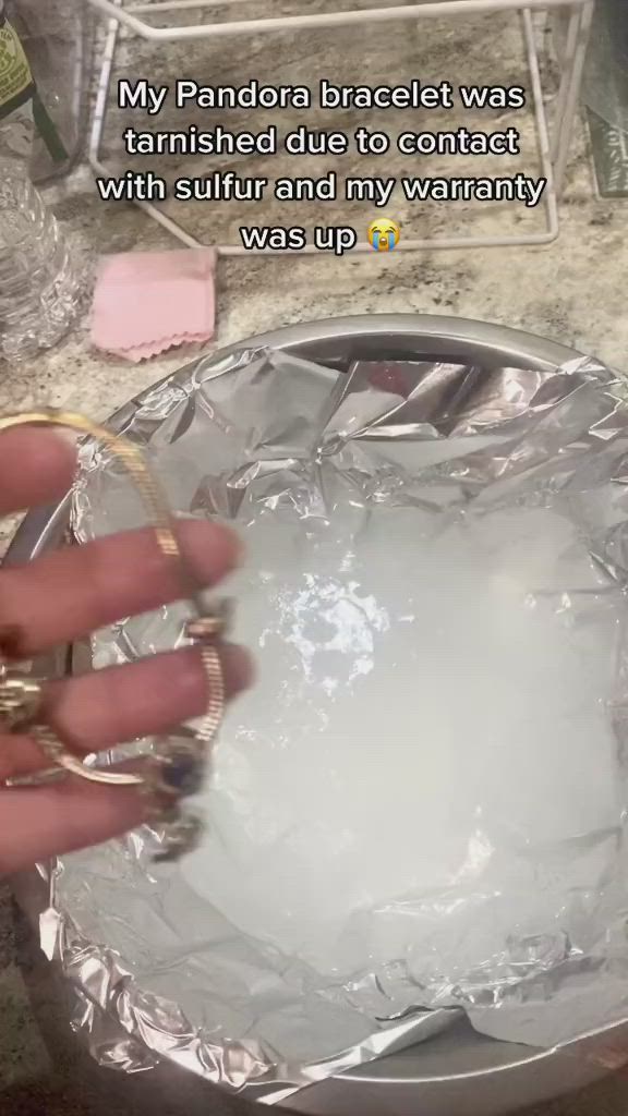 This may contain: a person holding onto a silver plate with rings on it's finger and saying, my pandada breastet was finished due to contact with stuff