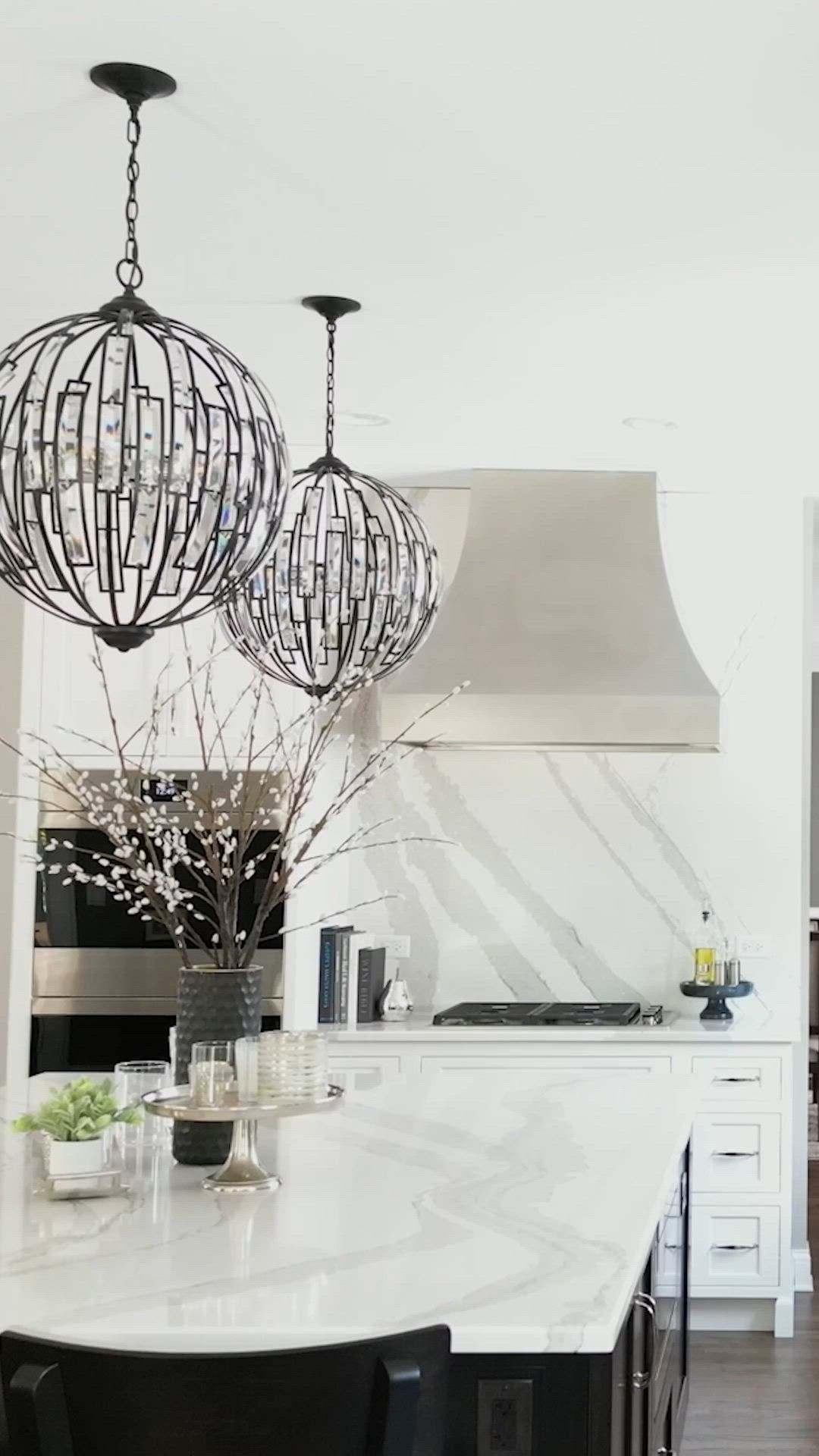 This contains: sophisticated black and white kitchen with light and bright fixtures