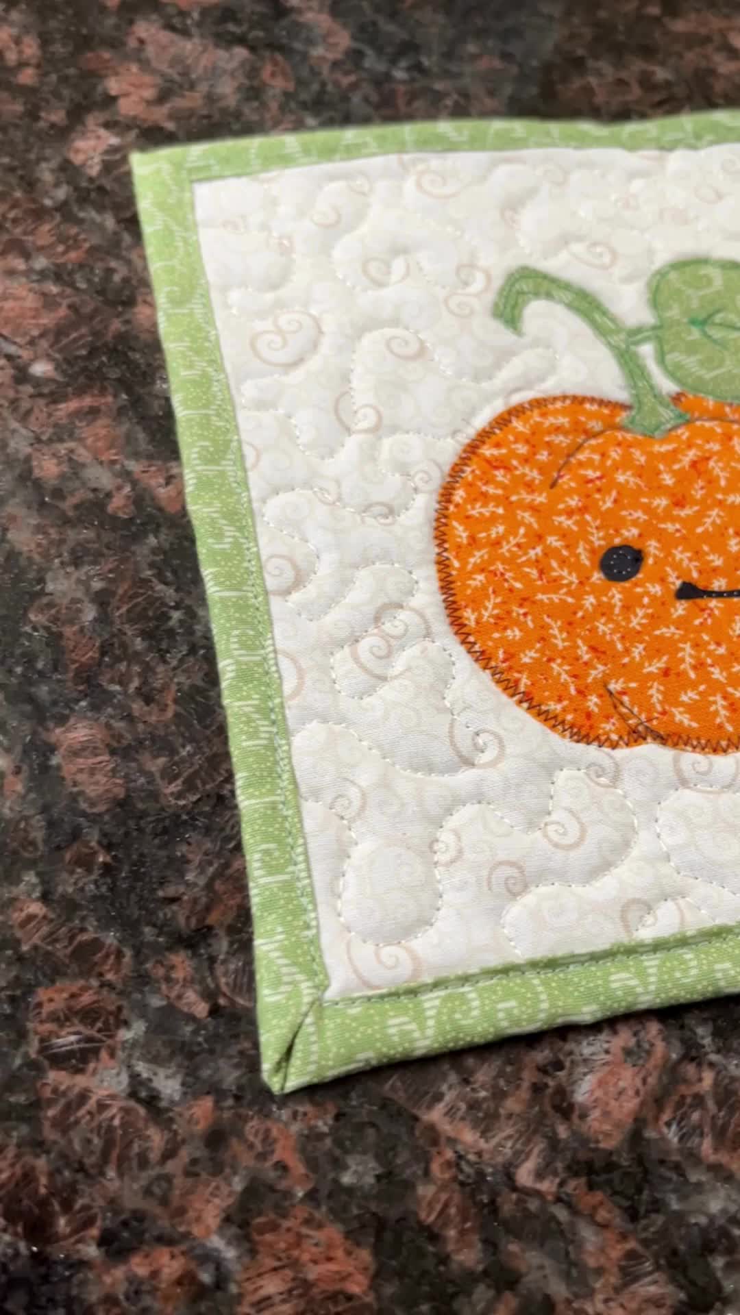 This may contain: a close up of a piece of fabric on a counter top with a pumpkin patch