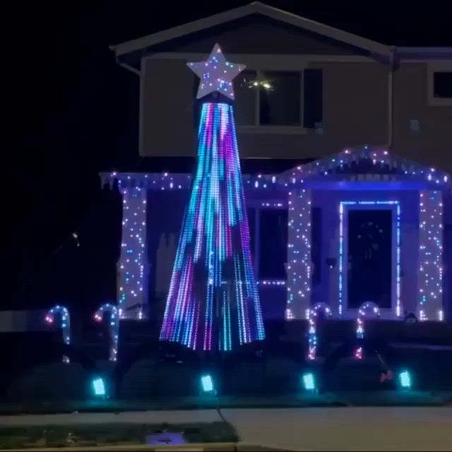 This may contain: a house covered in christmas lights with a tree