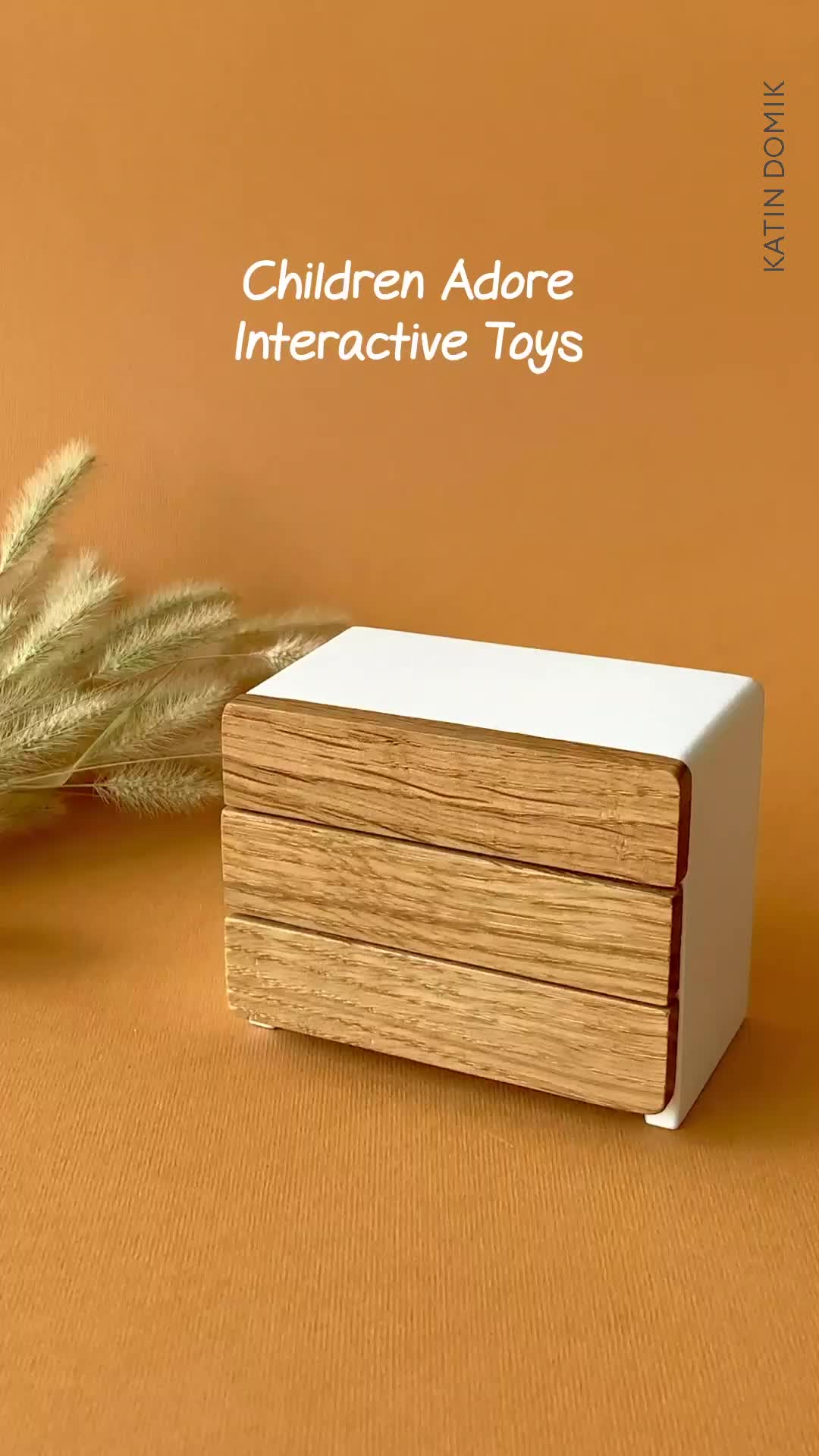 This may contain: an advertisement for children's interactive toys with a wooden box and grass on the table