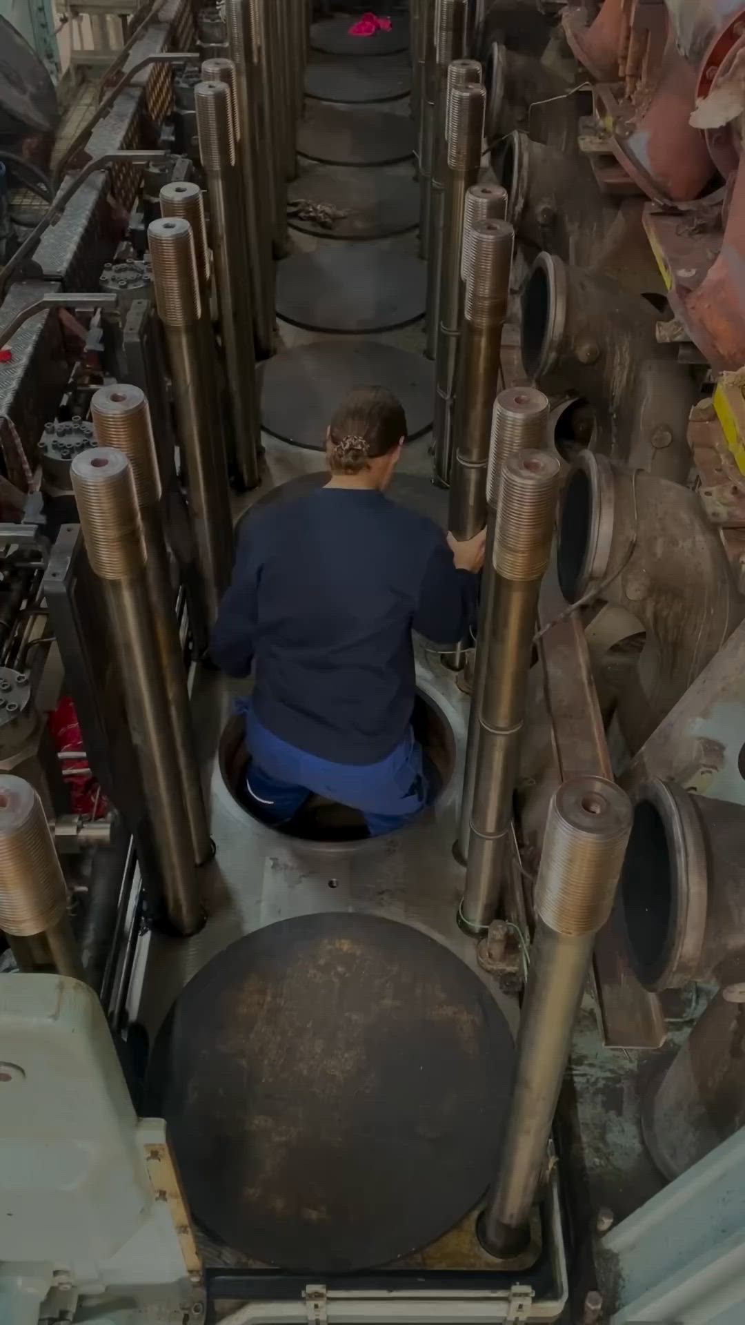 This may contain: a man working on pipes in a factory