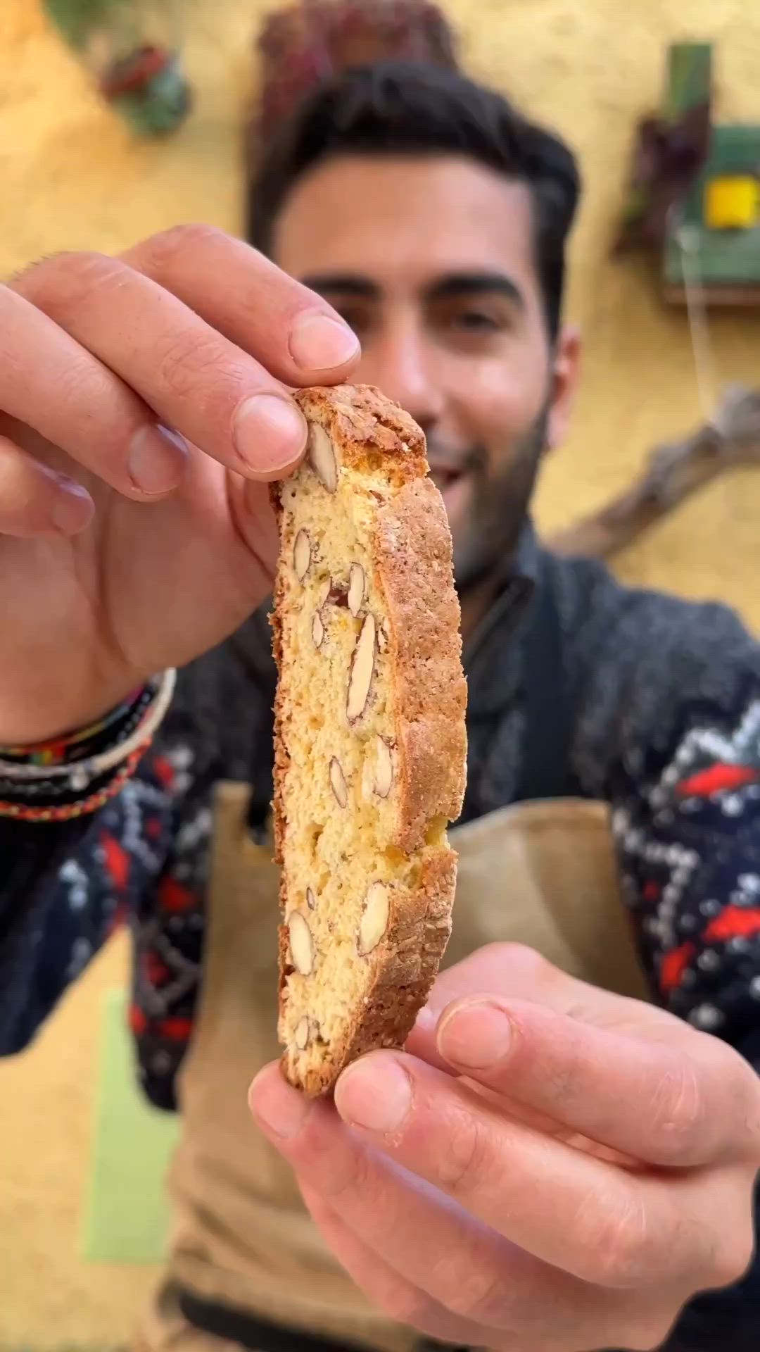 This may contain: a man holding up a piece of bread with nuts on it