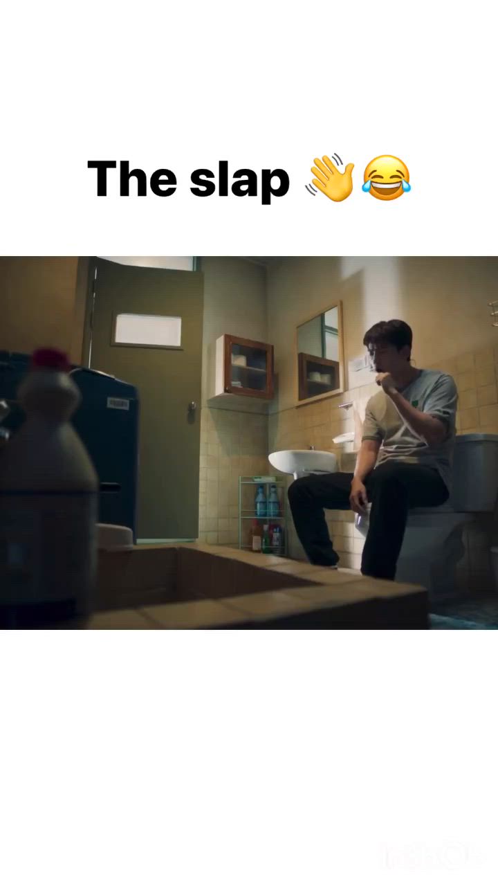 This may contain: a man sitting on top of a toilet in a bathroom next to a sink with the caption'the slap '