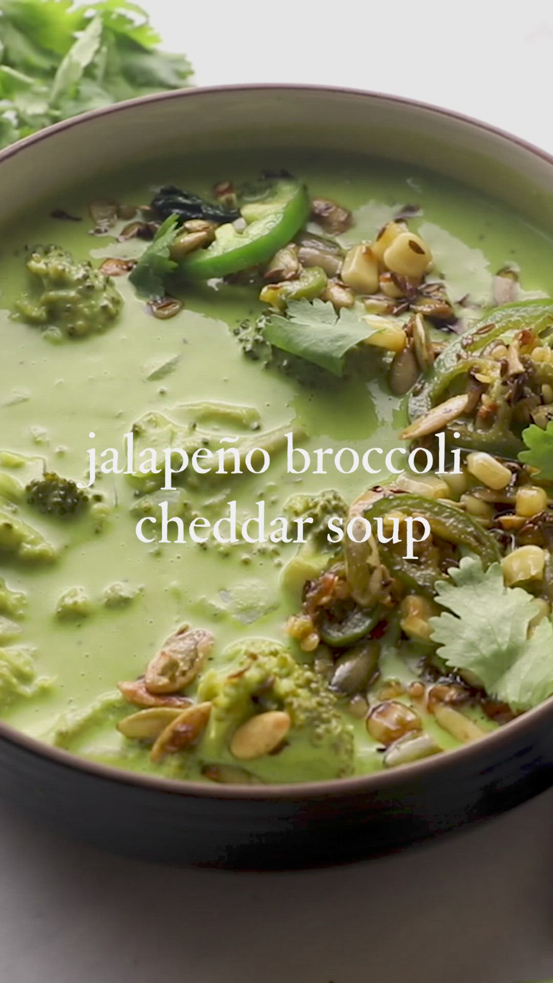 This may contain: a bowl filled with broccoli and other food on top of a white table