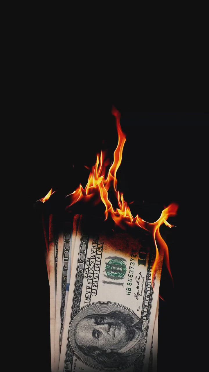 This may contain: a stack of money sitting on top of a pile of fire