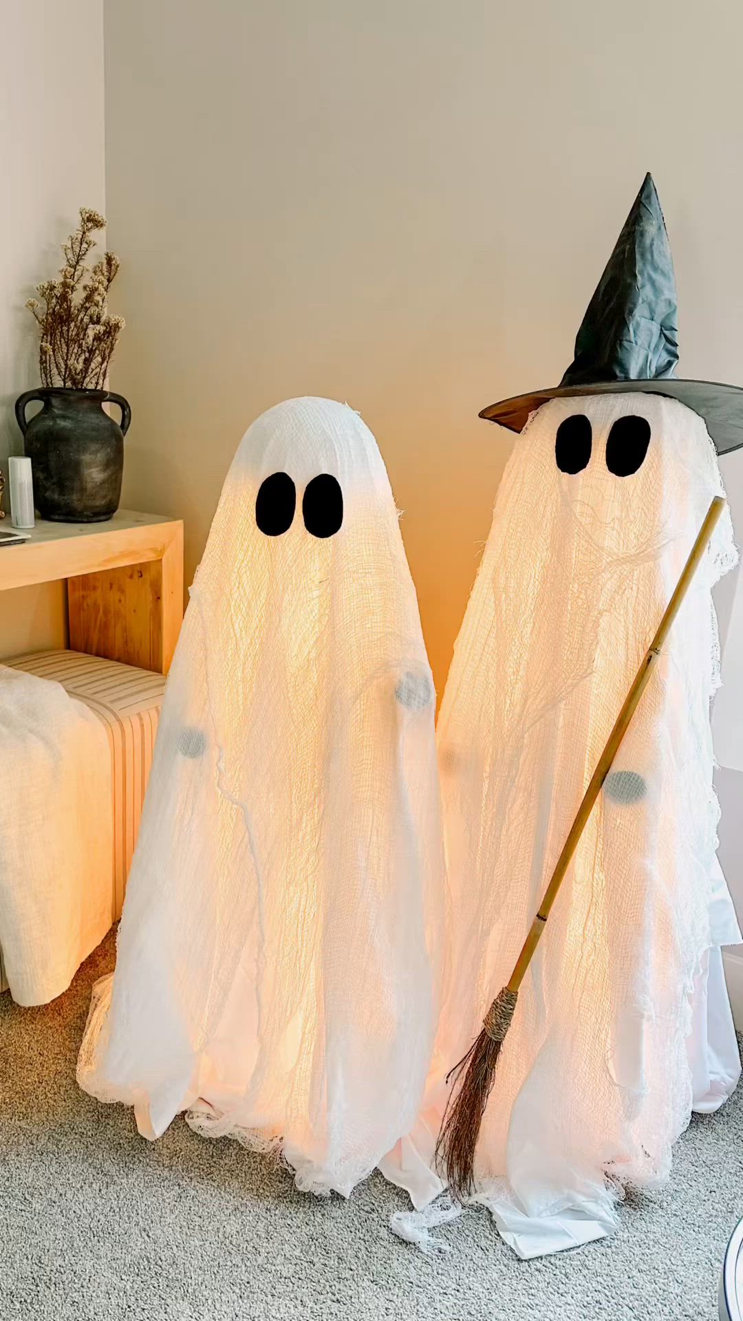 This may contain: two white ghost statues with black eyes and hats